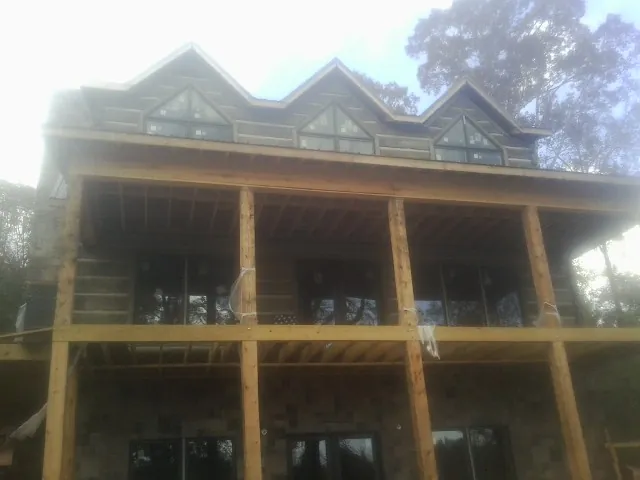 Dormers and porch framing on a large log home under construction — Roof Coating work by our crew in Gambrills