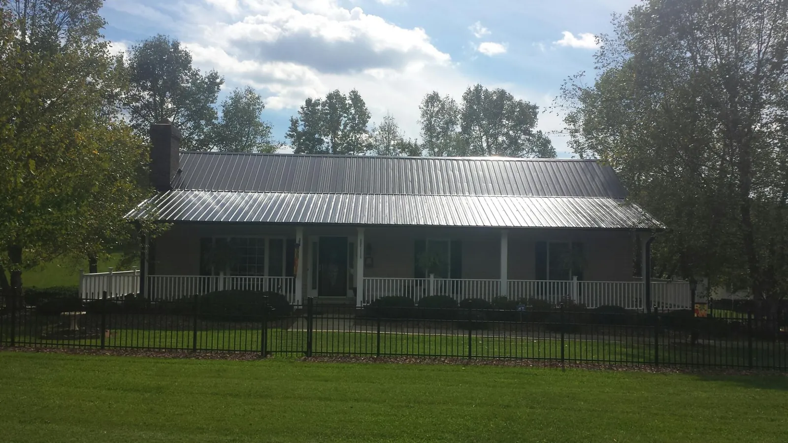 Gray metal roof on a brick ranch with a full width front porch — Gutter Guard Installation work by our crew in Gambrills