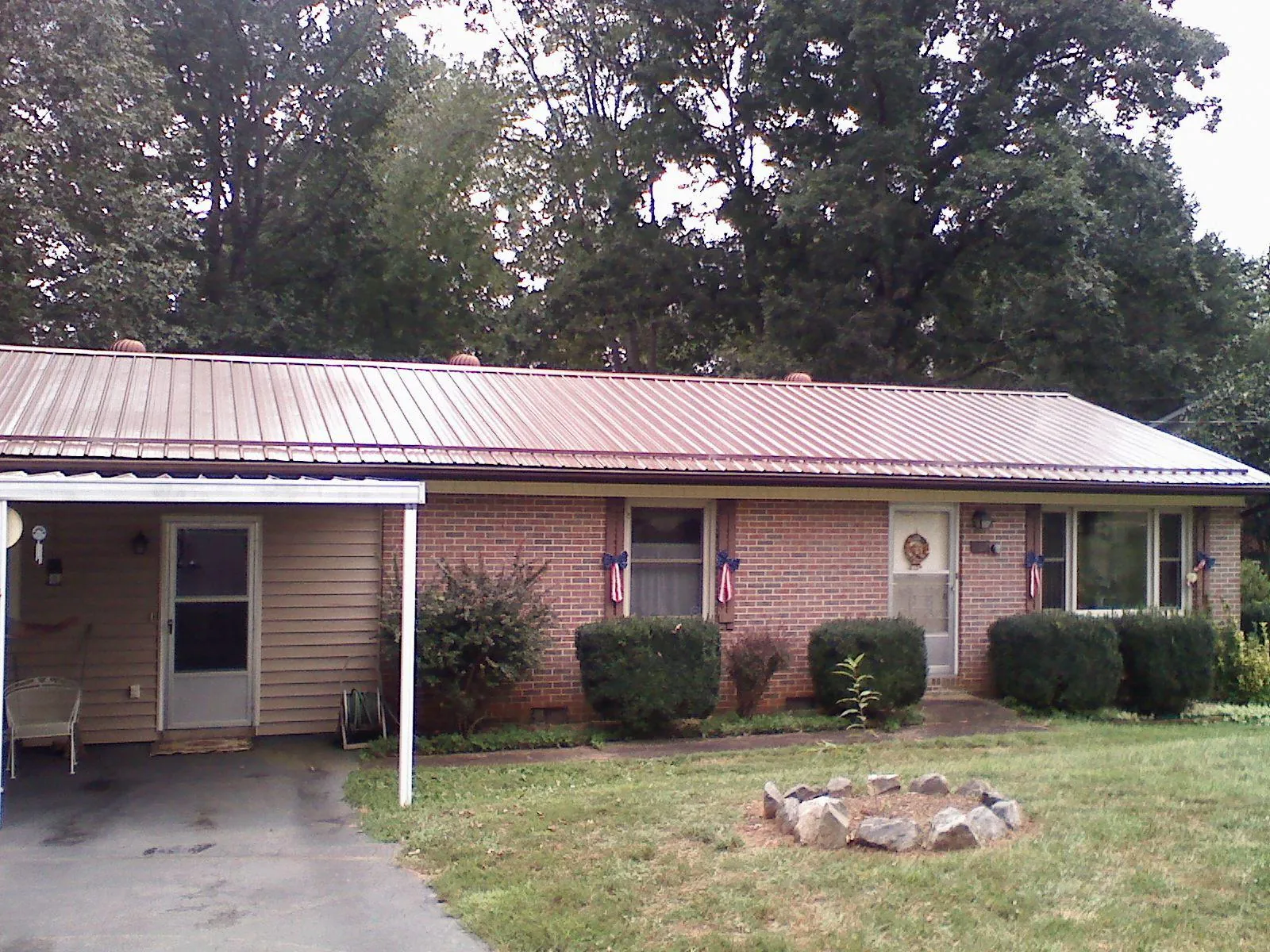 Bronze metal roof and carport on a brick ranch home — Roof Repair work by our crew in Gambrills